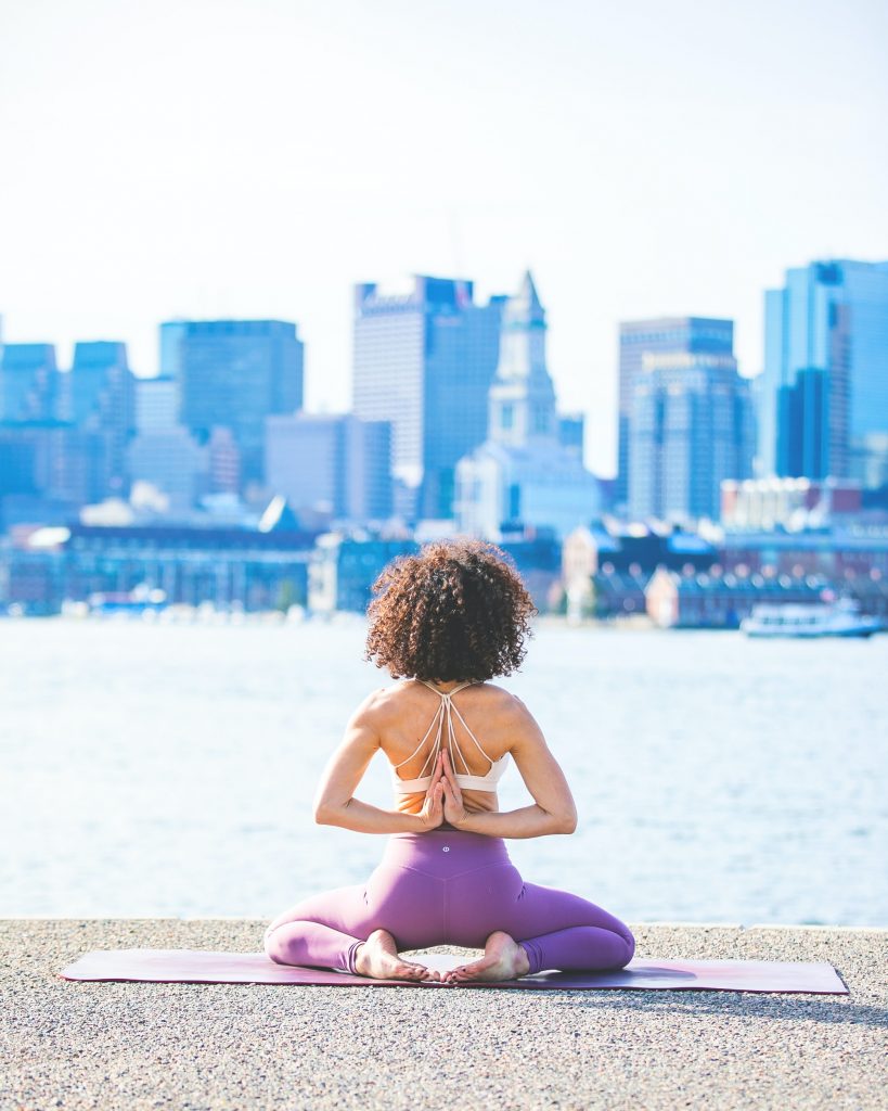 lululemon woman doing yoga in front of cityscape